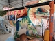 Los niños montan en el dinosaurio del parque temático para el equipo del entretenimiento